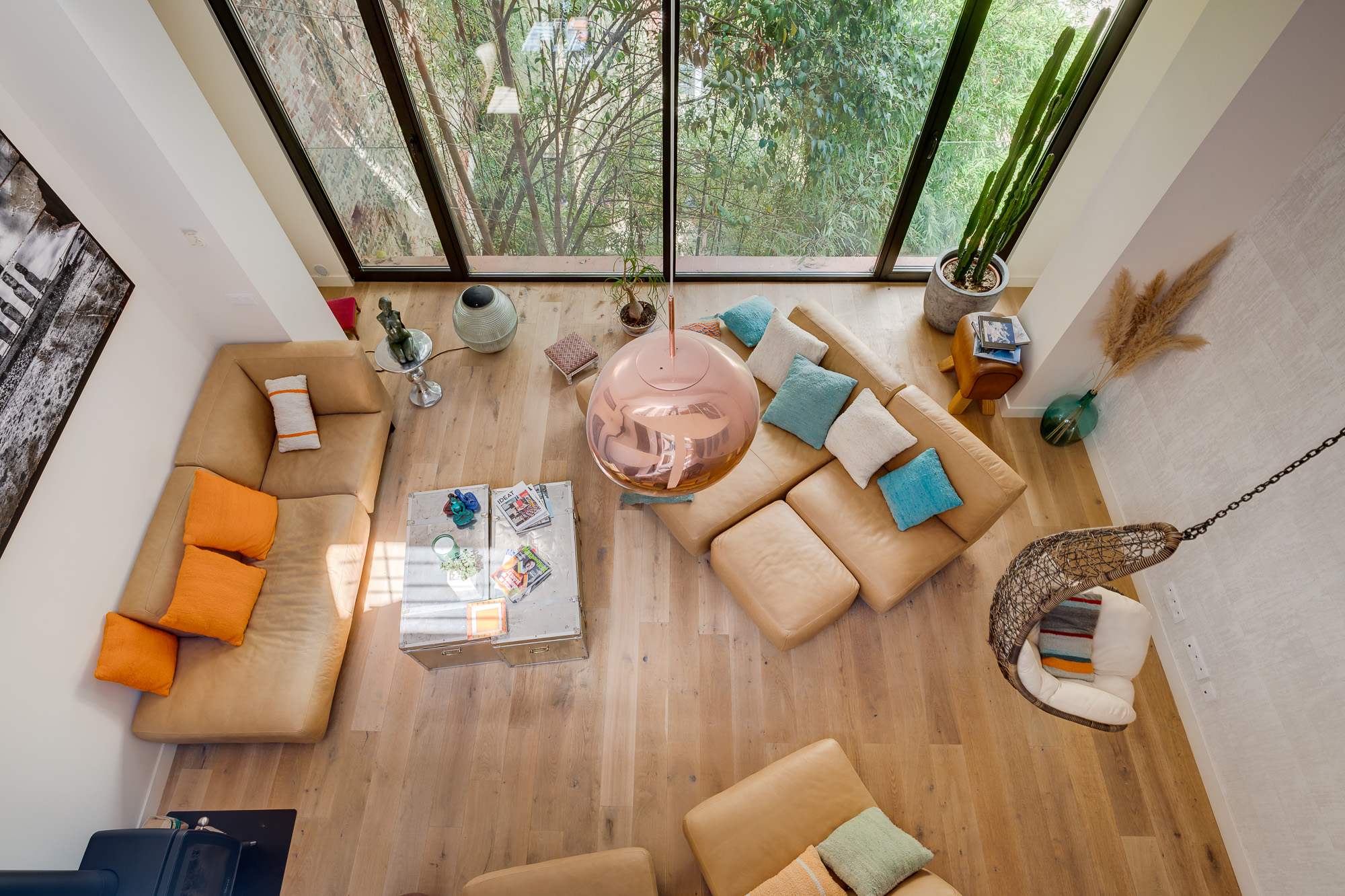 Appartement de luxe Toulouse Pikimo-6 Vue en plongée depuis la mezzanine sur le salon avec suspension cuivrée et baies vitrées — appartement de luxe Toulouse — reportage immobilier Pikimo