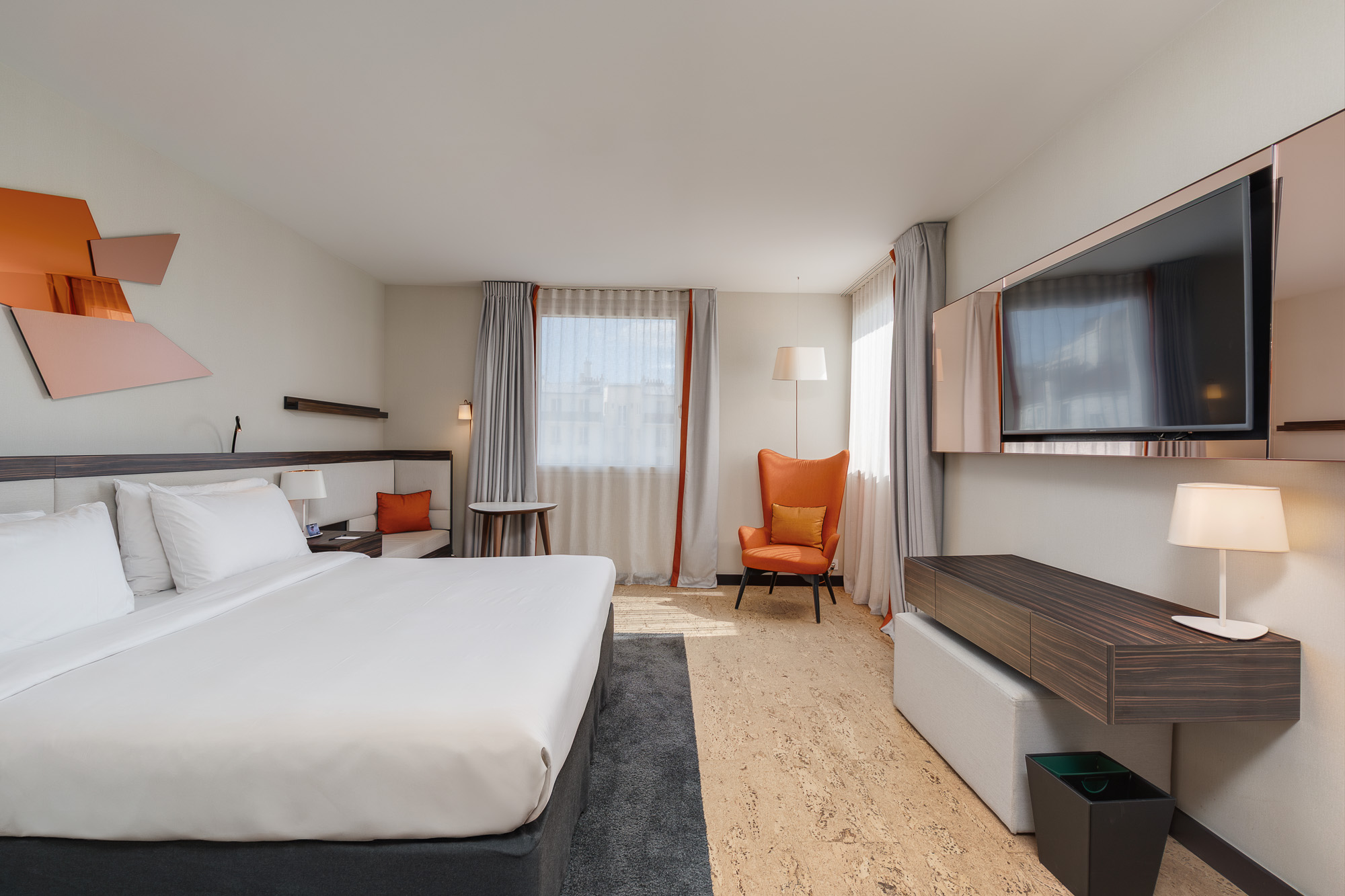 Chambre spacieuse télévision murale et fauteuil orange — DoubleTree by Hilton