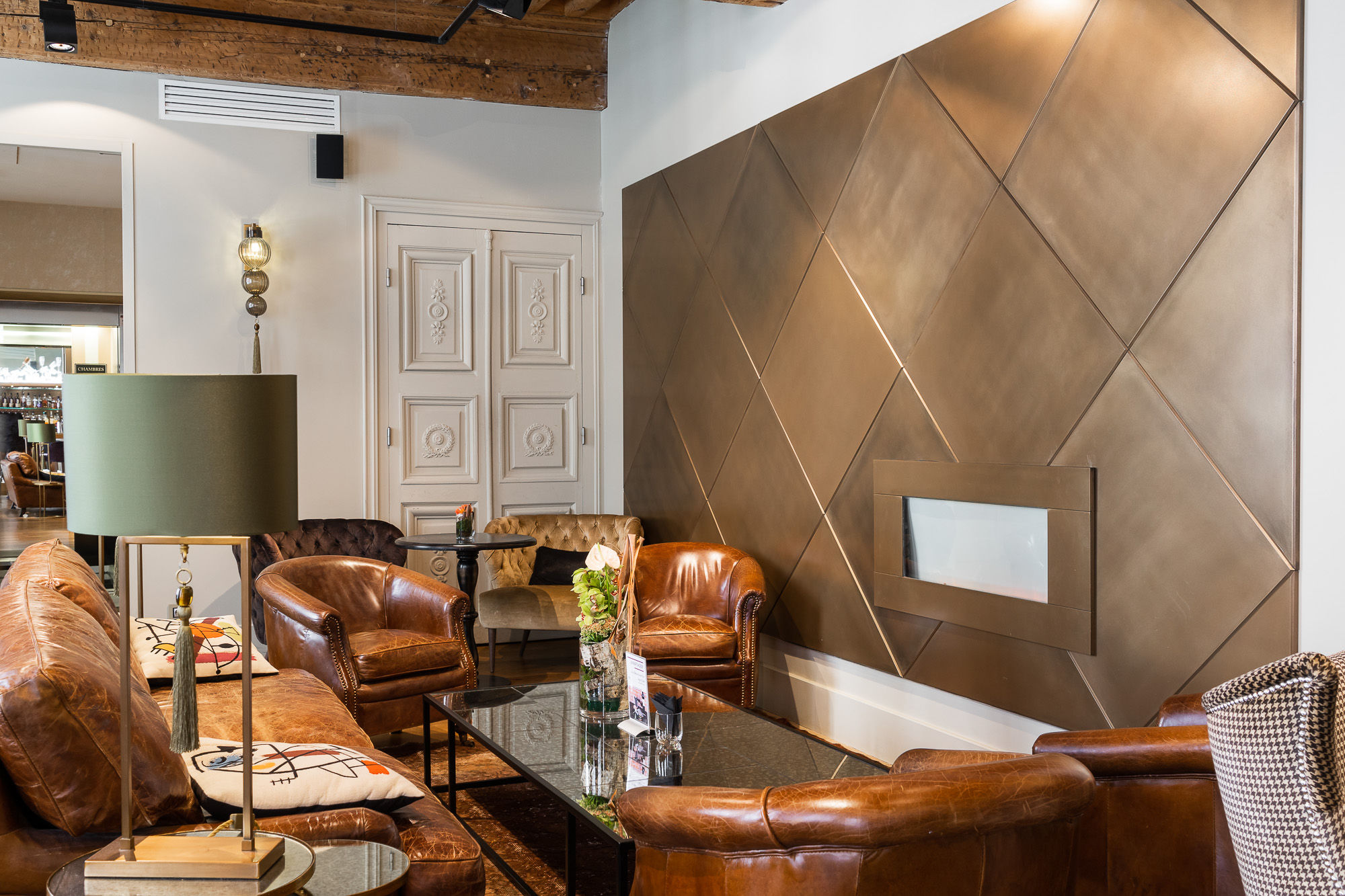 Salon bar mur métal doré et fauteuils vintage cuir — La Cour des Consuls Toulouse