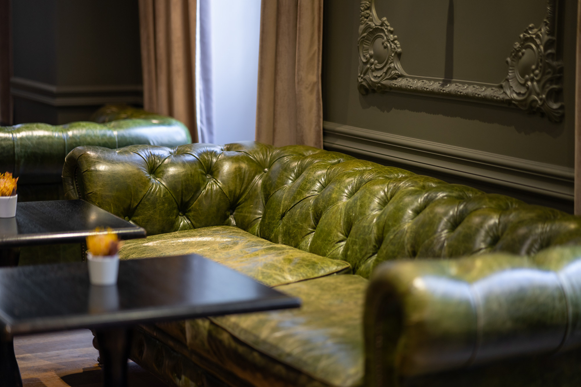 Détail canapé chesterfield cuir vert — bar lounge La Cour des Consuls Toulouse