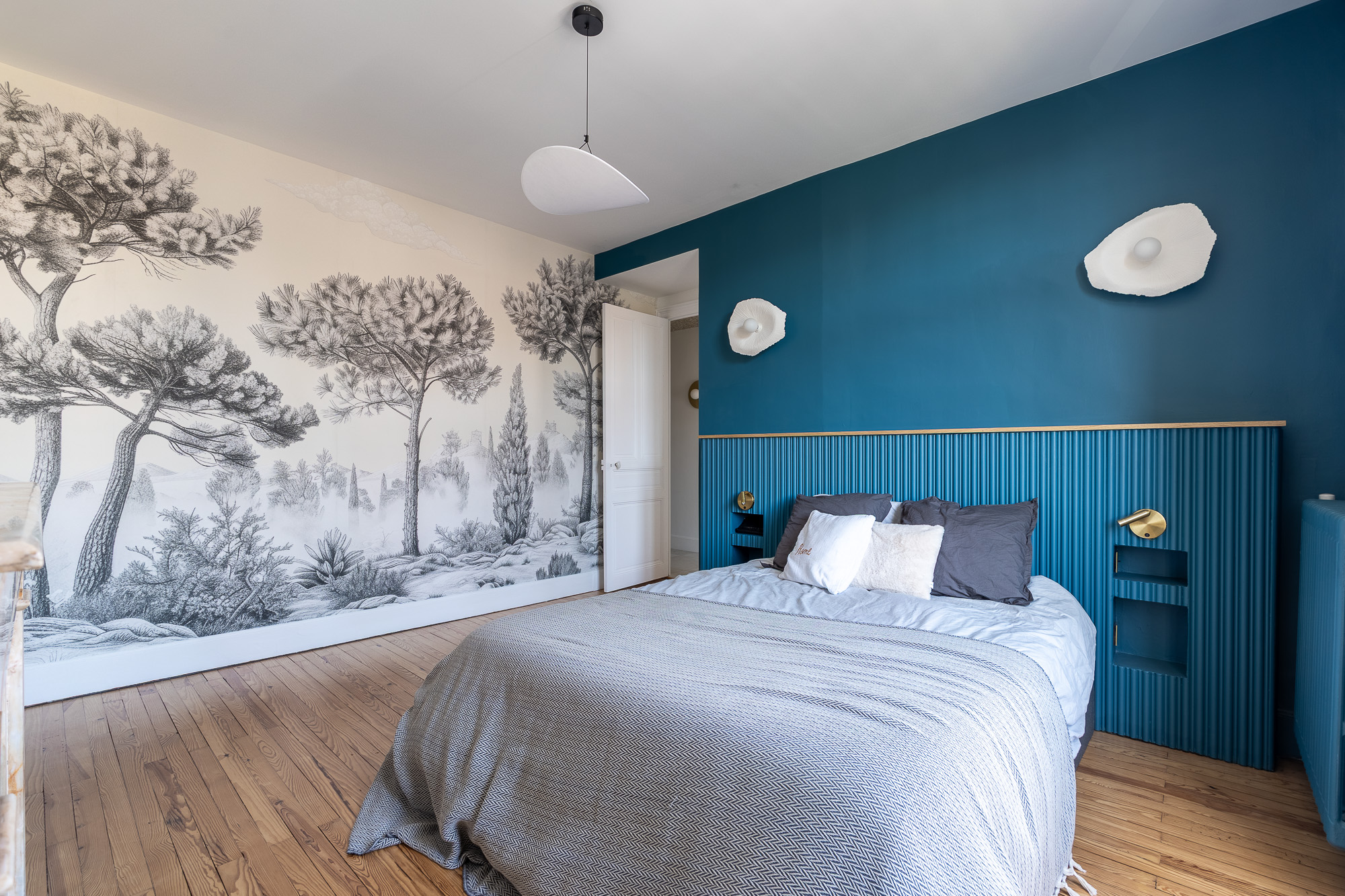 Chambre avec papier peint panoramique arbres et tête de lit cannelée bleue — rénovation appartement Toulouse LM Déco Marylène Laurent — reportage Pikimo