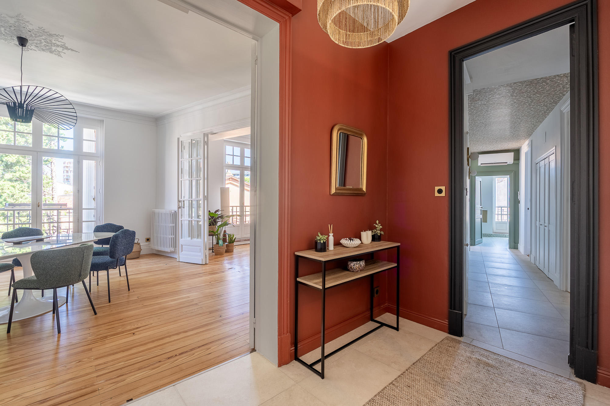 Entrée rénovée avec murs terracotta et vue sur salon lumineux — appartement haussmannien Toulouse — architecte d'intérieur LM Déco — photographe Pikimo