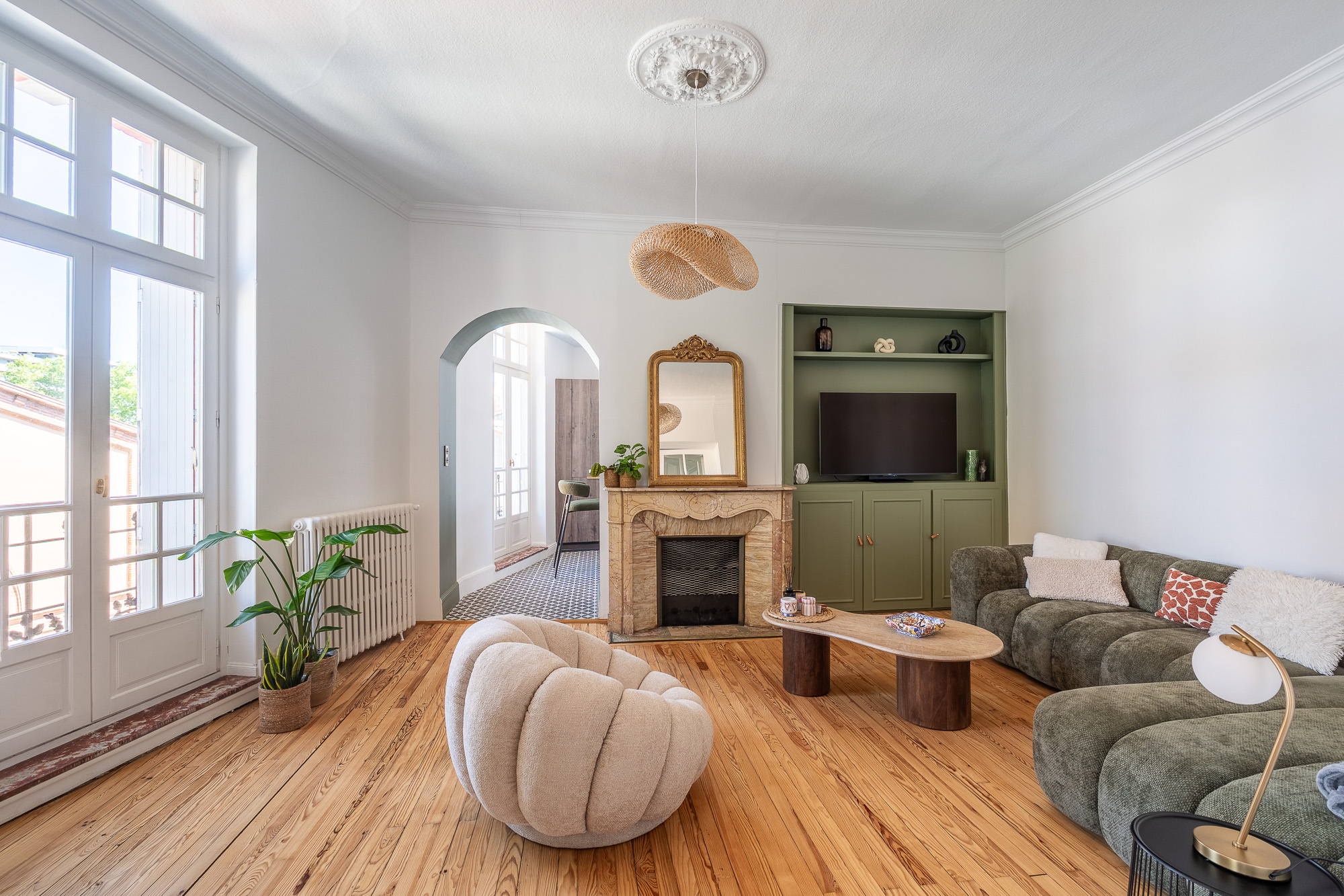 Salon avec cheminée en marbre, bibliothèque verte sur mesure et parquet ancien — rénovation appartement haussmannien Toulouse LM Déco — photographe Pikimo