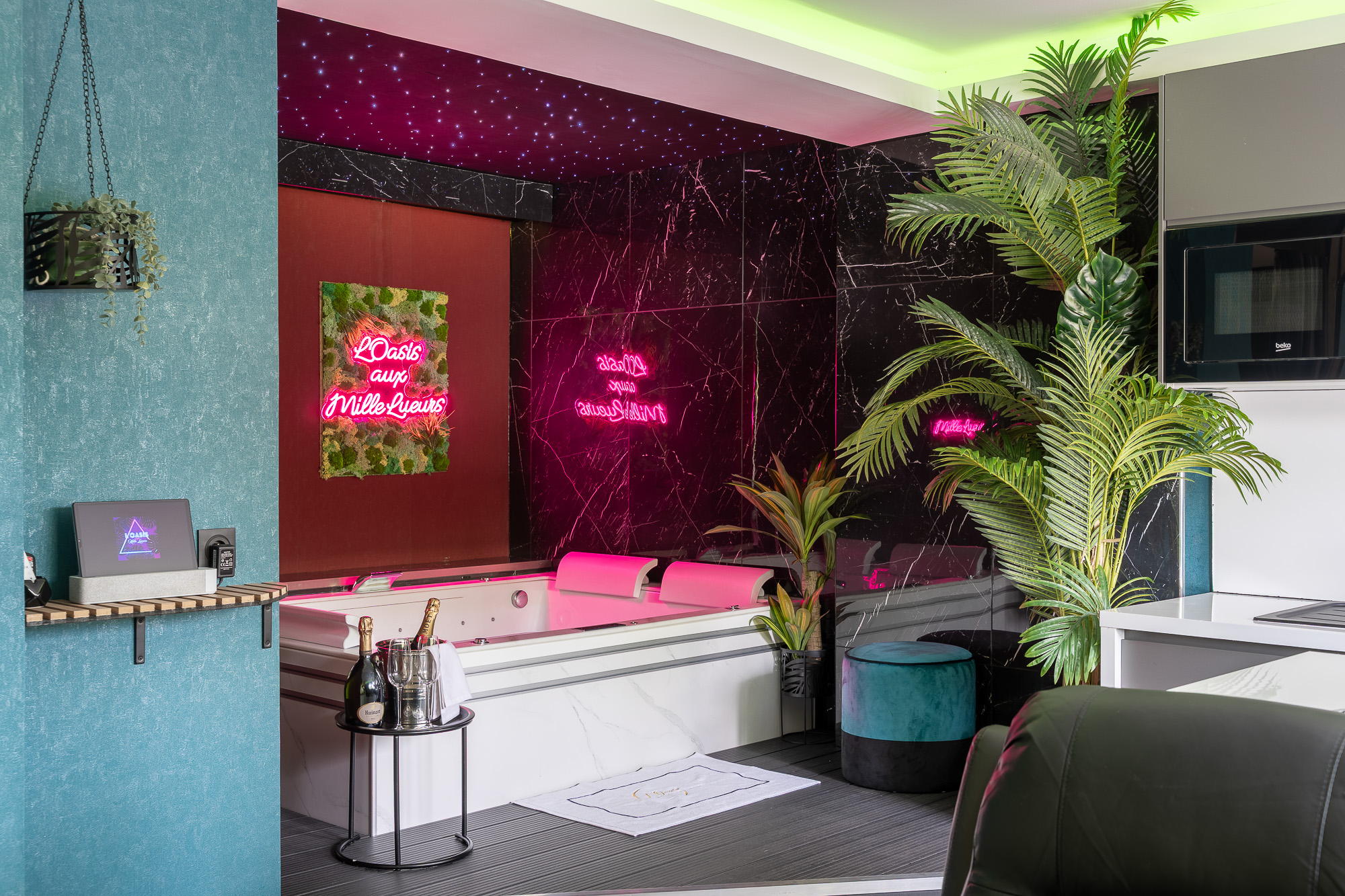 Espace jacuzzi néon rose et végétation tropicale — L'Oasis aux Mille Lueurs Airbnb Toulouse