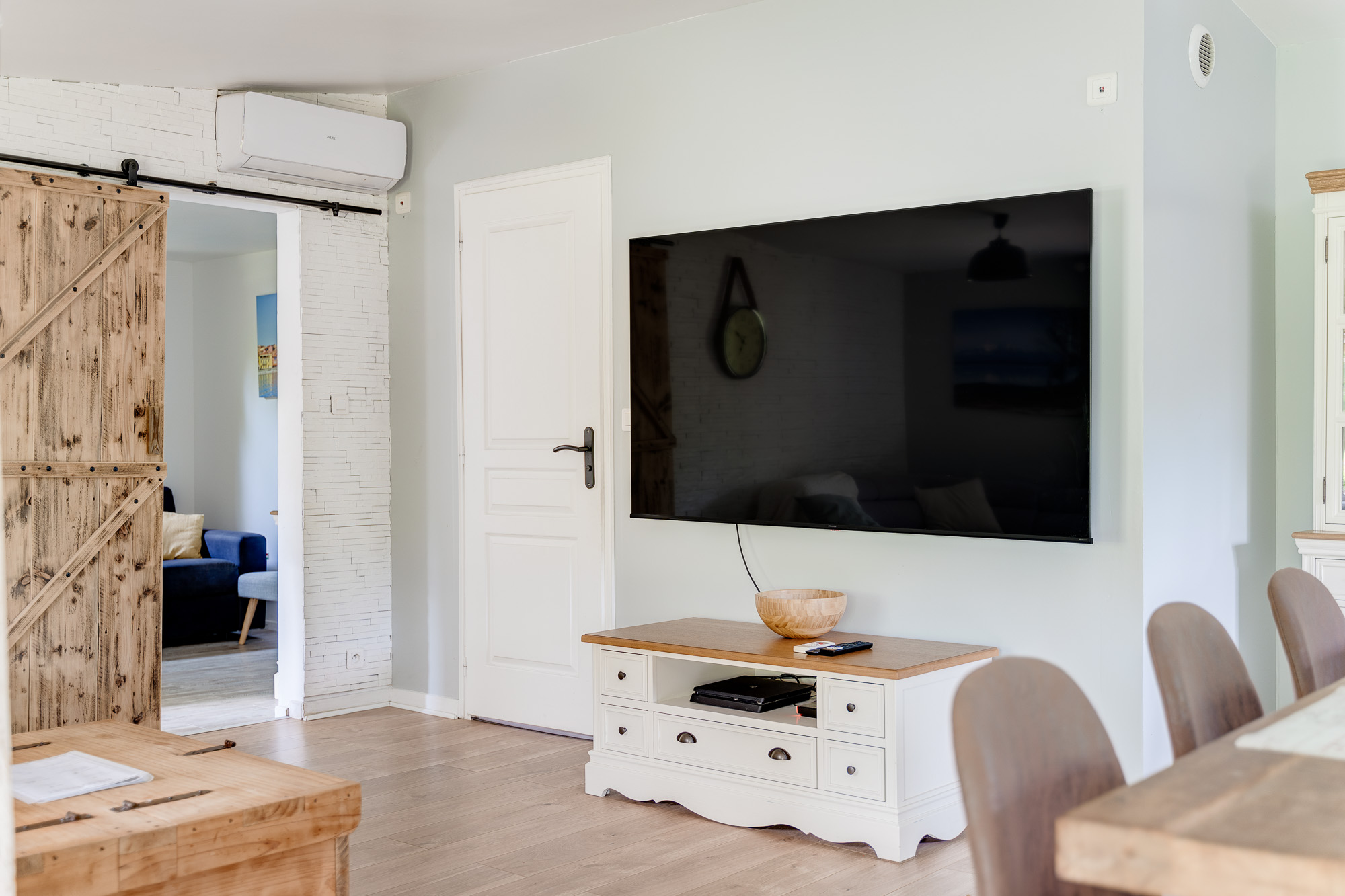 Coin télévision avec écran plat mural et meuble TV blanc