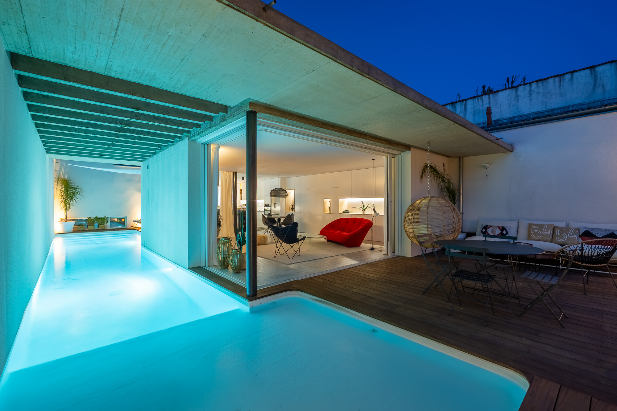 Maison de luxe Toulouse Pikimo photographe haut de gamme-2 Terrasse avec piscine illuminée de nuit et vue sur salon ouvert — maison de luxe Toulouse — photographe immobilier haut de gamme Pikimo