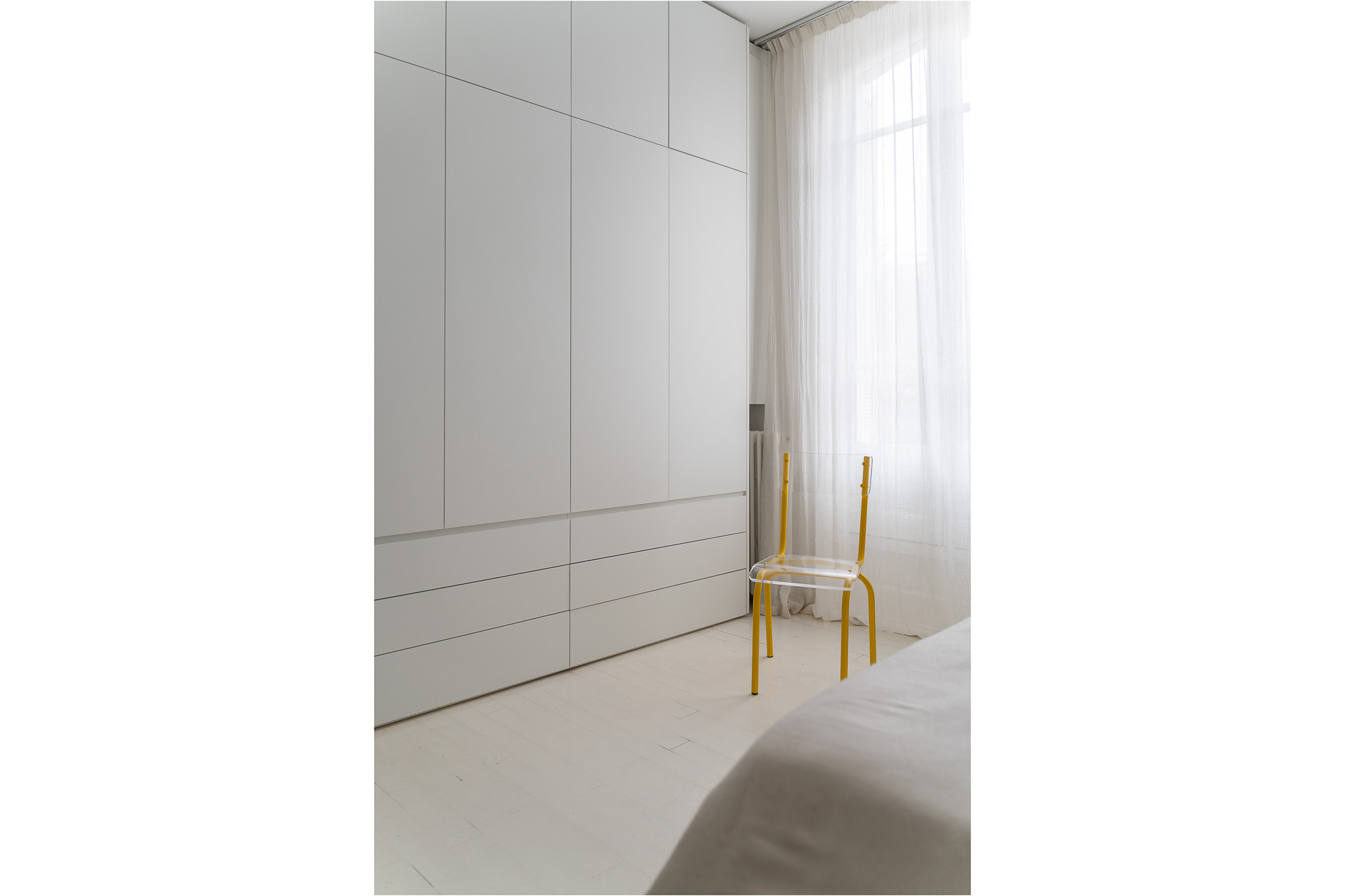 Chambre avec dressing intégré blanc et chaise jaune translucide — rénovation appartement Toulouse Merci Rose architecte d'intérieur — photographe Pikimo