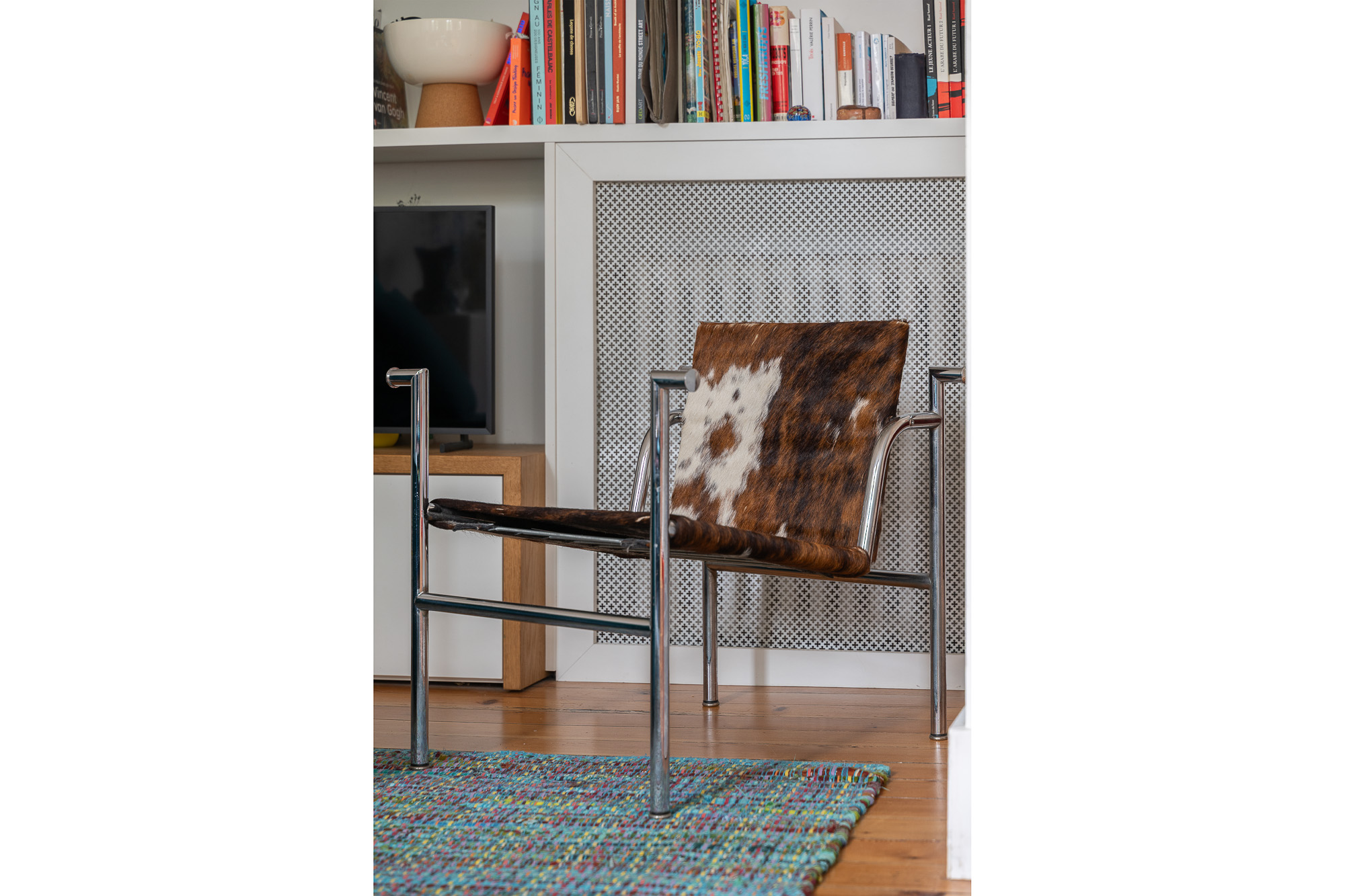 Détail fauteuil LC1 Le Corbusier en peau de vache dans salon rénové — appartement Toulouse Merci Rose architecte d'intérieur — reportage Pikimo