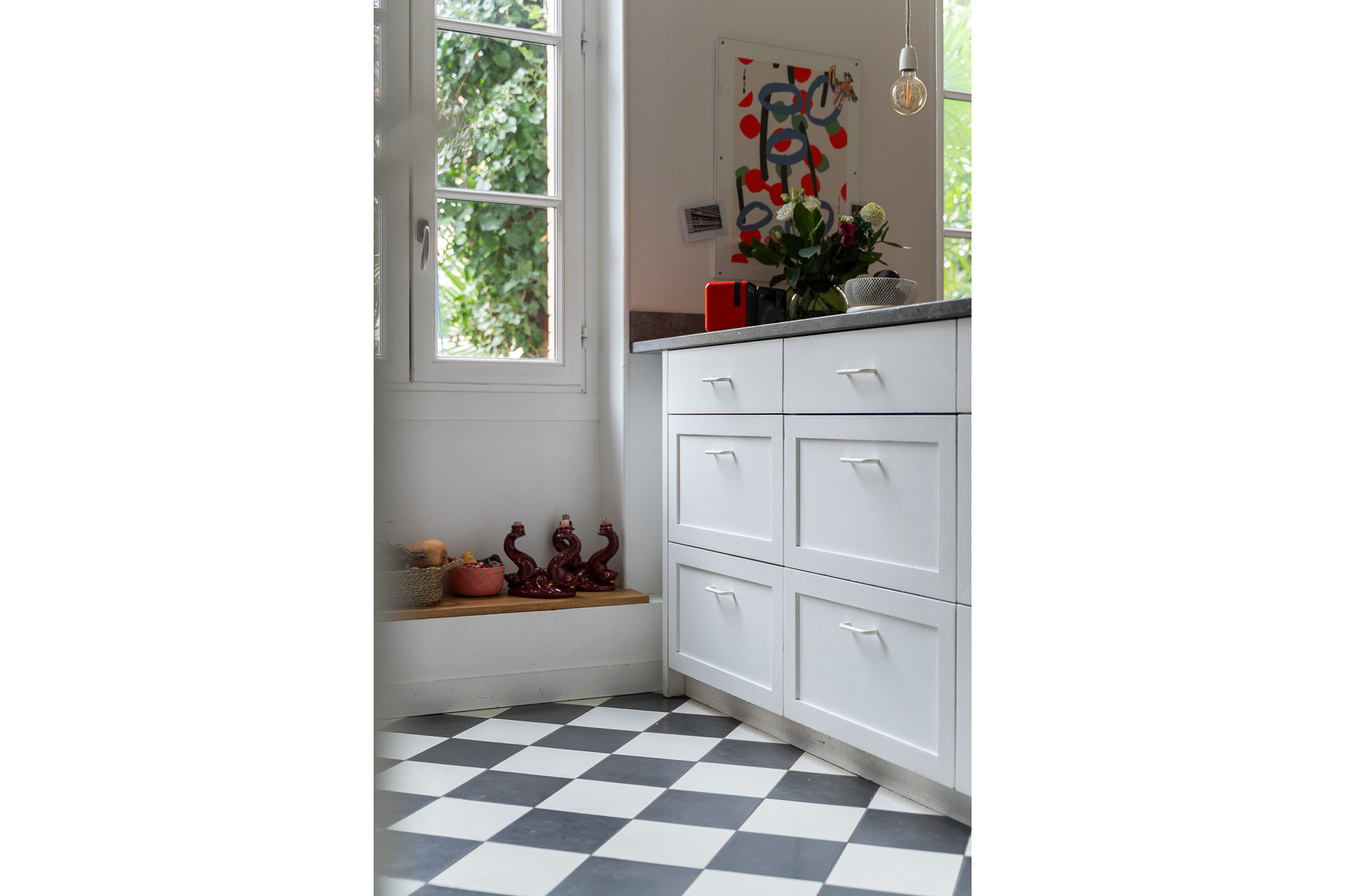 Coin cuisine avec meuble blanc et carrelage damier et vue sur jardin — rénovation appartement Toulouse Merci Rose architecte d'intérieur — reportage Pikimo