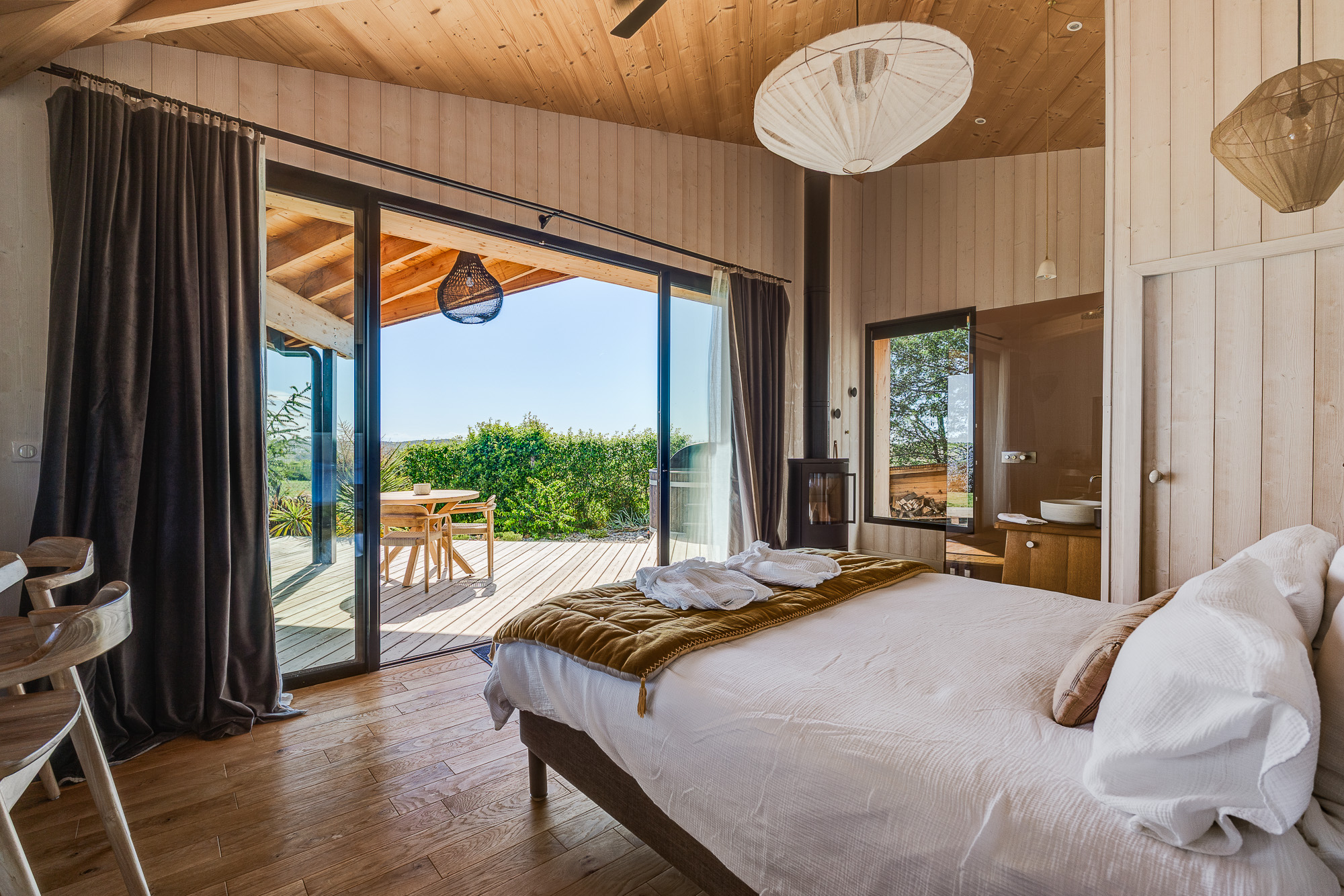 Chambre lit et baie vitrée ouverte sur terrasse — location Airbnb Nomad's Co Toulouse
