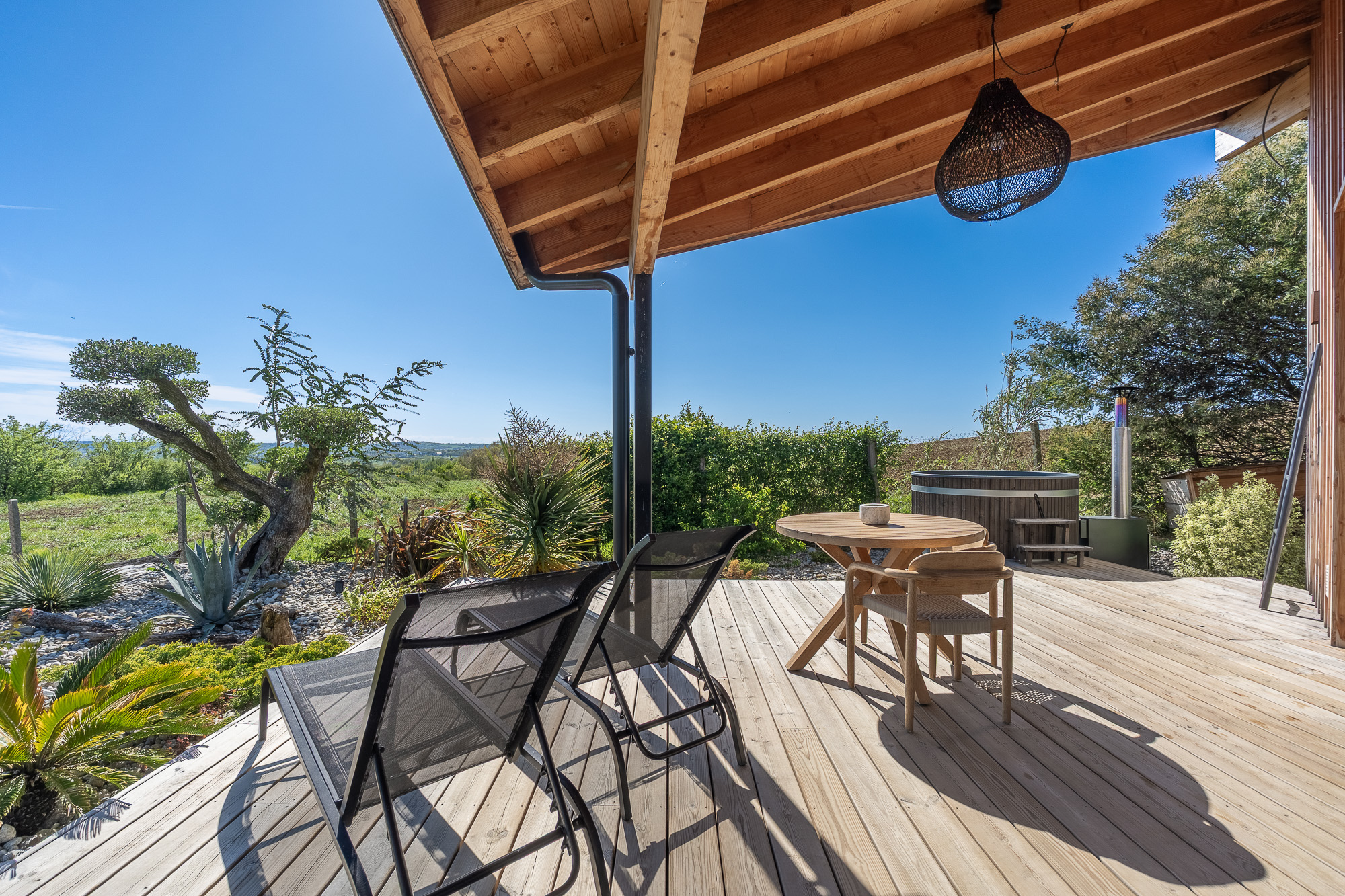 Terrasse bois transats et bain nordique vue campagne — Airbnb Nomad's Co Toulouse