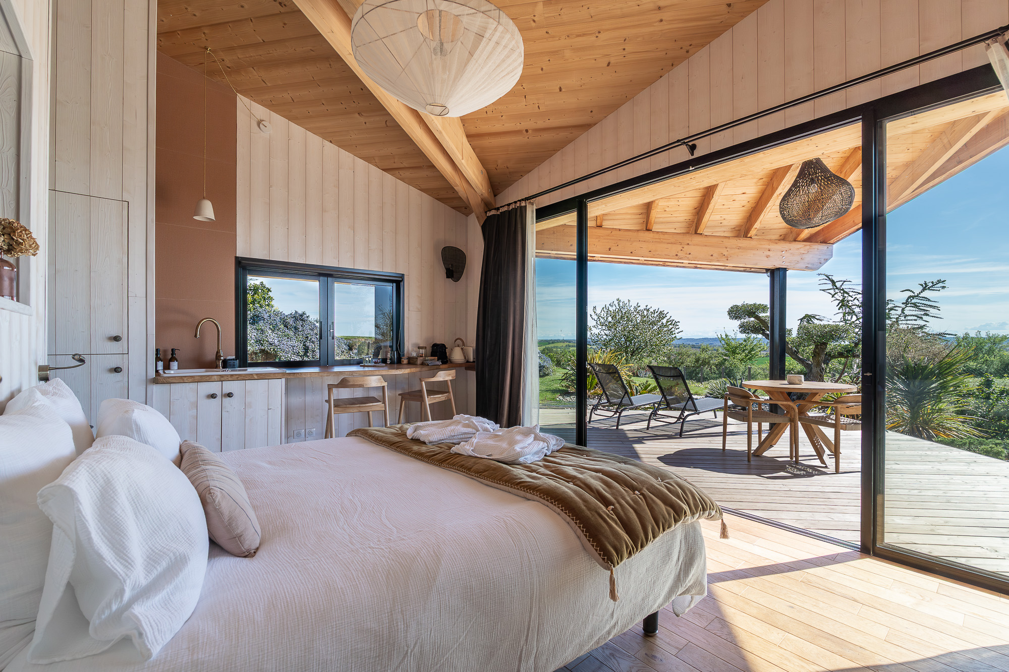 Chambre kitchenette et baie ouverte sur terrasse — cabane Nomad's Co Toulouse